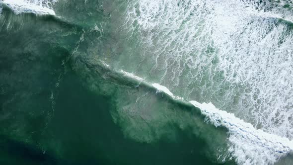 Aerial - Waves rolling out diagonally, beautiful patterns of whitewash and sandy bottom being distur