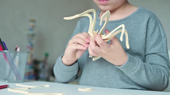 Close-up of a wooden toy in the hand of a child who assembles it with his own