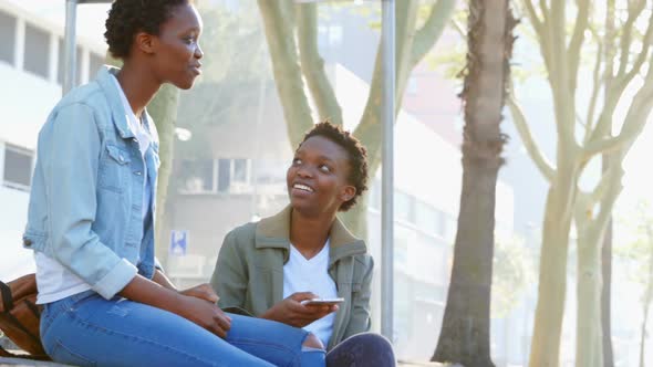 Twin sisters interacting with each other in the city 4k