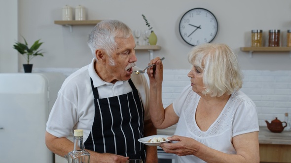 Senior Woman Feeding Man with Raw Sprouts Buckwheat with Nuts. Eco Food Eating Diet. World Vegan Day