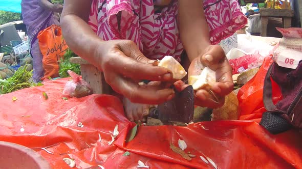 HIKKADUWA, SRI LANKA - MARCH 2014: Woman slicing vegetables with sharp knife at Sunday market.