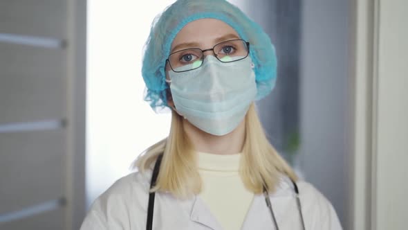 Tired Female Doctor or Hospital Worker Takes Off Her Mask