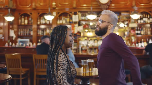 Happy Multiethnic Man and Woman Smiling and Dancing in Restaurant