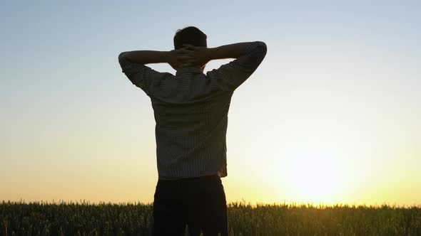 Happy Farmer Enjoys the View of the Wheat Field and the Successful Outcome of His Farming Work