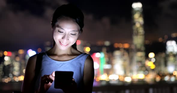 Woman Looking at Mobile Phone at Night 