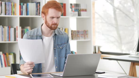 Casual Redhead Man Doing Paperwork in Office