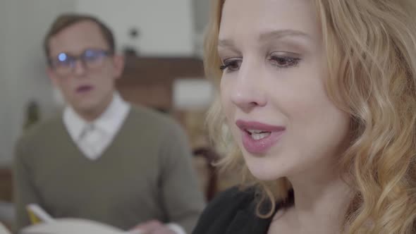 Close Up Face of Beautiful Blond Woman Reading Aloud the Book in the Foreground While Modestly