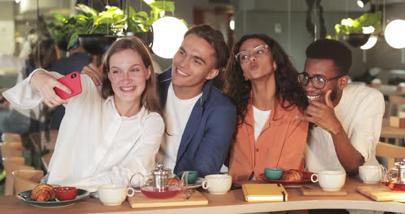 Crop View of Happy Coworkers Posing for Selfies While Having Lunch. Millennial Multiethnic Friends