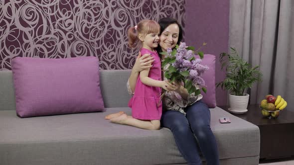 Little Daughter Child Congratulates Mother with Bouquet of Flowers. Slow Motion