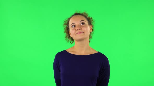 Portrait of Curly Woman Daydreaming and Smiling Looking Up. Green Screen