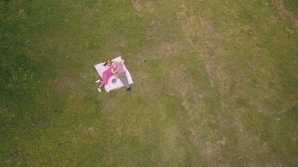 Family Weekend Picnic in Park. Aerial View. Senior Old Couple Lie on Blanket on Green Grass Meadow