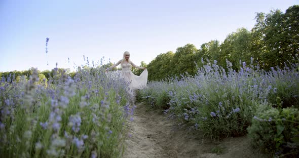 Cinematic View of Woman Dancing Colorful Lavender Fields on a Sunny Day Blooming Purple Flowers.