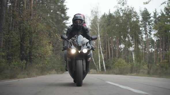 Wide Shot of Young Motorcyclist in Helmet Riding with Girlfriend on Back Seat. Portrait of Confident