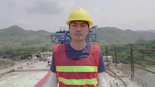 Asian Man Walking On Construction Bridge Crossing River