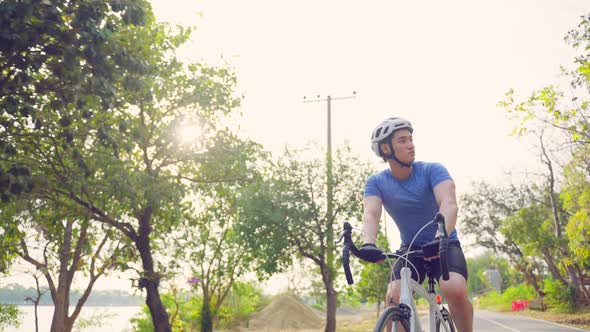 Asian young active sport male riding bicycle for health in public park.