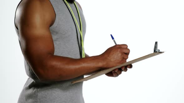 Attentive trainer writing on clipboard