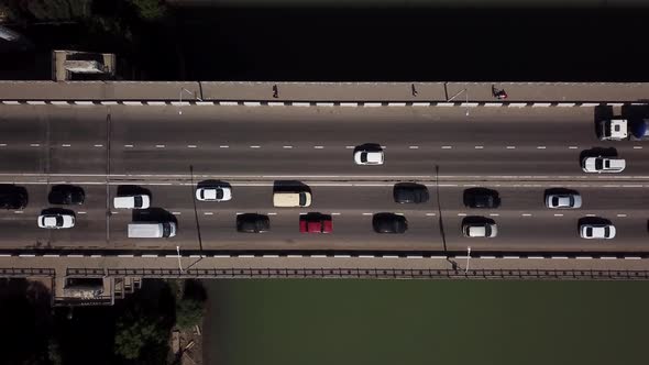 Drone's Eye View Aerial Top Down View Of Traffic Driving Over A Modern Bridge