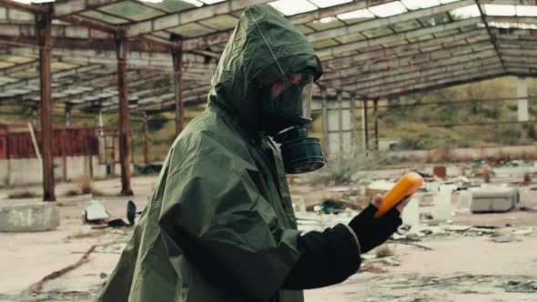 Man with Radiation Mask and Geiger Counter Checks a Nuclear Site