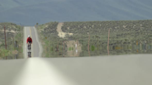 A man road biking on a scenic desert road