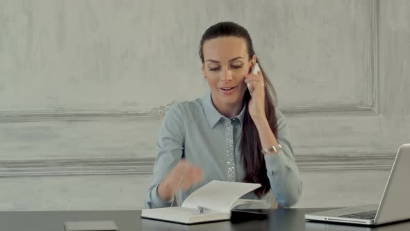 Happy Businesswoman Talking on the Cell Phone in Modern Office