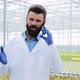 Agricultural Engineer in a Greenhouse Using Mobile, Talking on Smartphone - VideoHive Item for Sale