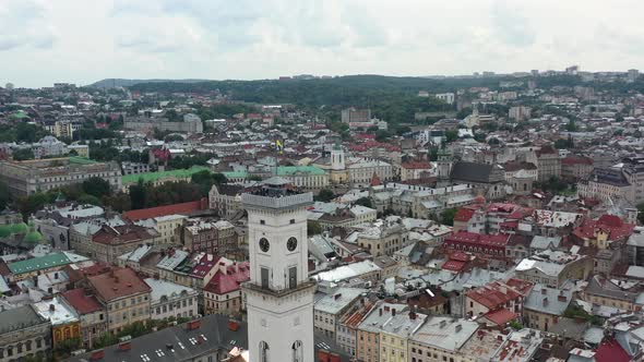 Tower in Rynok Square of Lviv Ukraine flying the Ukrainian flag with tourists on top overlooking the