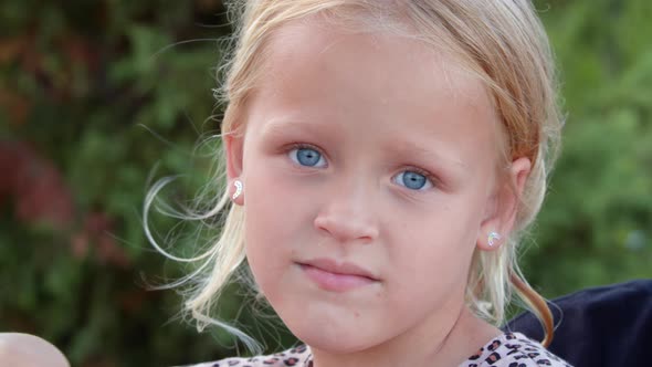 Outdoor Portrait of Lovely Little Girl with Blue Eyes