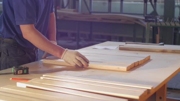 Carpenter arranging wood planks