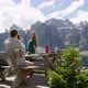 Man photographing woman at picnic table in landscape, Alta Badia, Italy - VideoHive Item for Sale