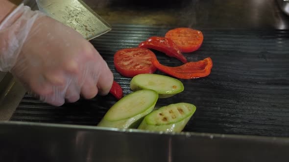 Close-up of a Restaurant Chef Grilling Tomatoes, Peppers and Zucchini.