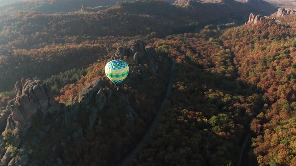 Hot air balloon flying over picturesque rock formation