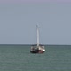 Sailboat tied to an anchor with no sail on a calm sea with a big blue sky - VideoHive Item for Sale