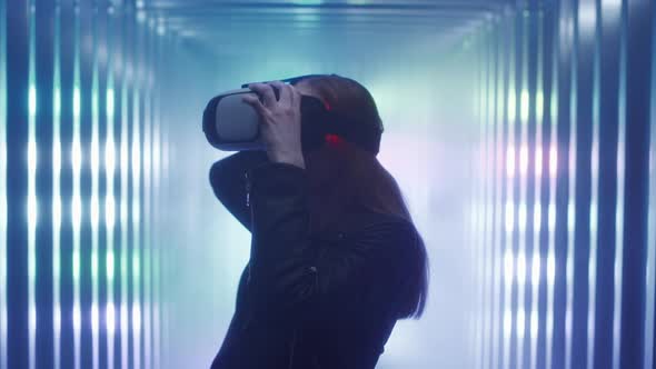 A Beautiful Young Girl Puts on Virtual Reality Glasses on Her Head