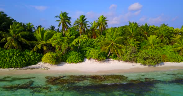 Tropical above abstract shot of a sandy white paradise beach and blue ocean background in colorful 4