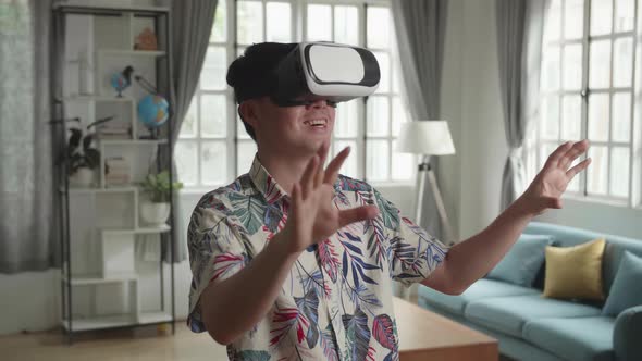 Asian Man Working In Virtual Reality Interface At Home
