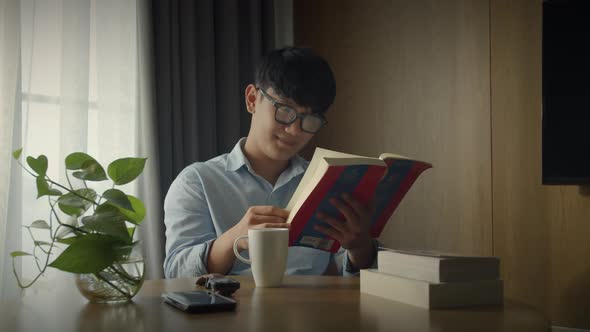 Young Attractive Asian Vietnamese Man is Busy Working Learning on Desk Book at Home Data Analyst