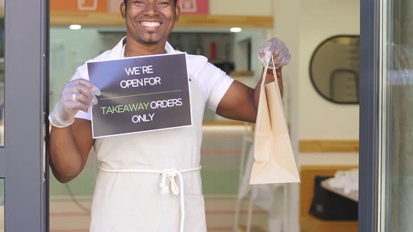 Portrait of Black Worker of Cafe Holding Sign