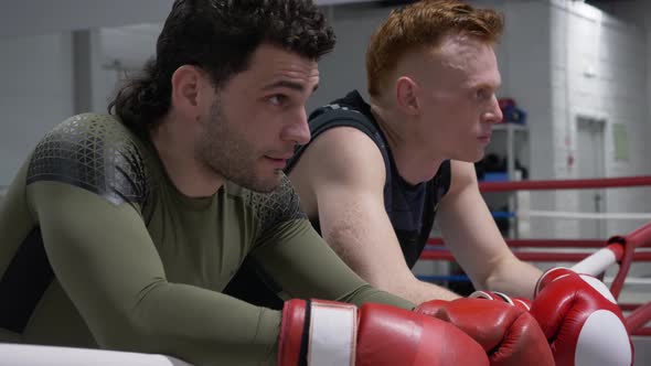 Two Boxer in Boxing Gloves Resting After Training on Ring in Fight Club, Tired Fighter Relaxing