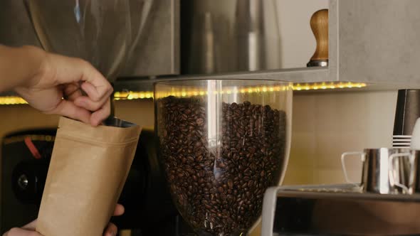 Barista putting fresh coffee beans in a craft bag in cafe it slow motion closeup with 4k.