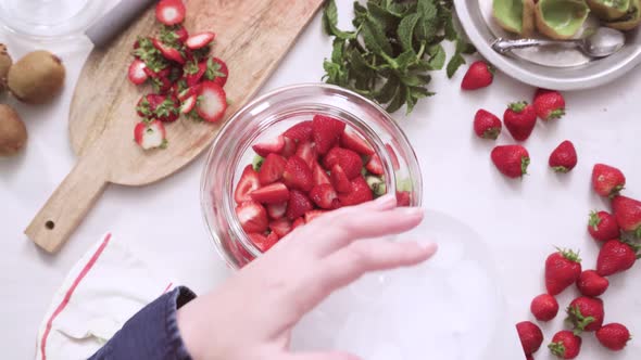 Step by step. Preparing organic infused water in glass beverage drink dispenser.