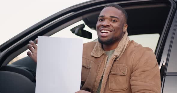 Male Driver Behind the Wheel with Sheet of Paper