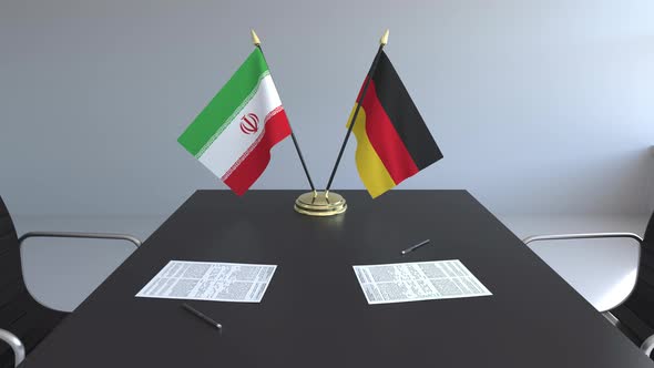 Flags of Iran and Germany and Papers on the Table