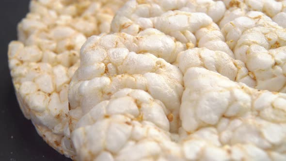 Crunchy dry rice cakes on black slate stone background. Healthy snack. Macro