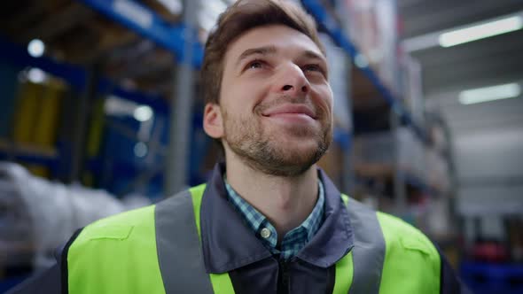 Closeup Portrait of Handsome Brunette Unshaved Man with Brown Eyes Smiling Looking at Cargo Racks in