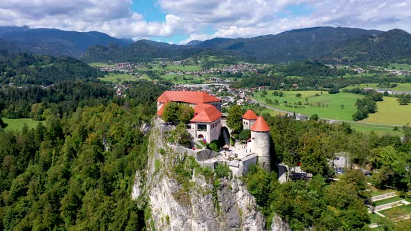 Cinematic front view of fairy tale castle surrounded by lake and mountains