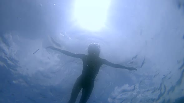 Underwater Shot of Elegant Woman Swimming Snorkelling in the Ocean Sunbeams in the Clean Water