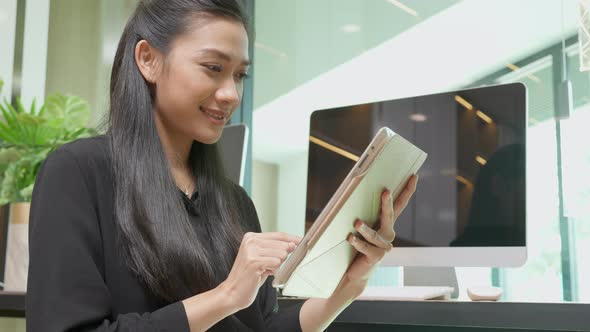 Young asian businesswoman using tablet computer working at office, woman or employee looking tablet.