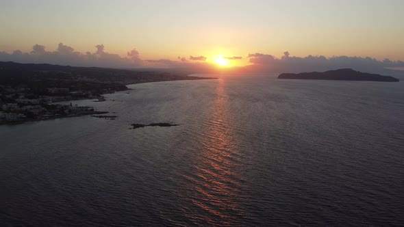 Aerial View of Sunset on Rocky Beach with Lighthouse in Crete Greece