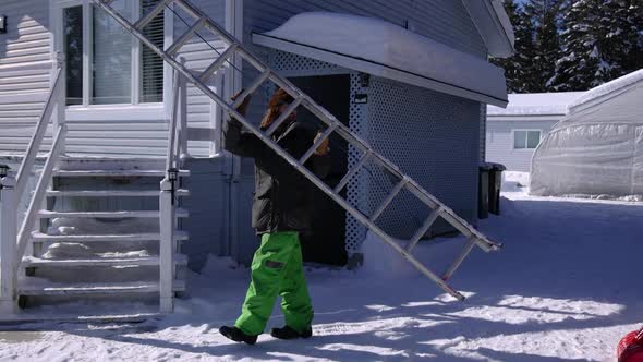 Removing Fresh Snow From a Roof in a Sunny Winter Day