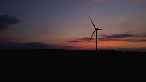 Silhouette of Windmill Turbine in Field at Sunset Sky